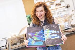 Carly York displays the pages displaying the blanket octopus in her book 丛林女王