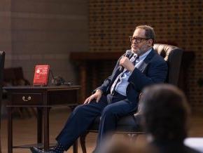Michael Eric Dyson sits in a chair on a stage