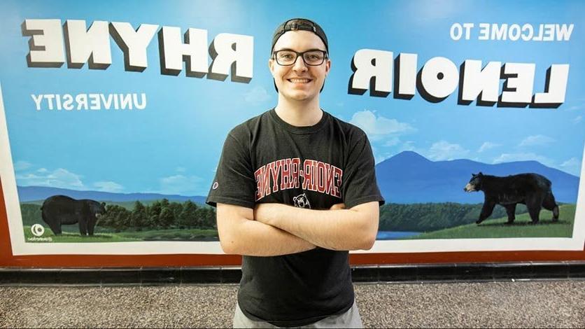 Mason Strother stands in front of his painted Lenoir-Rhyne mural on campus